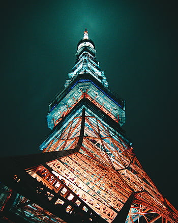 Stunning low-angle capture of Tokyo Tower glowing under night sky, showcasing its architectural brilliance. HD phone wallpaper