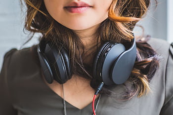 Stylish close-up of a woman with heads around her neck, showcasing modern music fashion. HD wallpaper