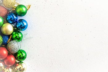 Bright and colorful Christmas ornaments arranged neatly on a light background with copy space. HD wallpaper