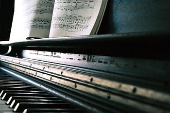 Close-up of piano keys with an open sheet music, creating a classic musical ambiance. HD wallpaper
