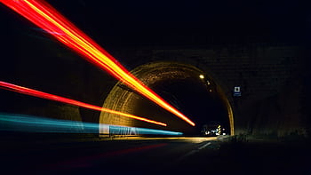 Dynamic long exposure capturing streaks of car lights through a tunnel at night. HD wallpaper