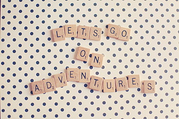 Scrabble tiles spell 'Let's go on adventures' on a polka dot background. HD wallpaper