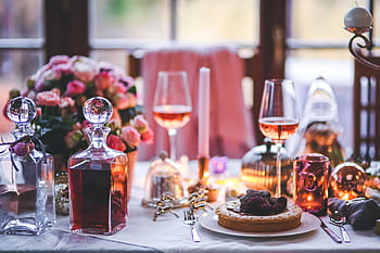 A beautifully set table with wine, flowers, and festive decorations, perfect for holiday celebrations. HD wallpaper