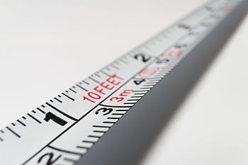 Detailed close-up of a measuring tape indicating measurements in feet and meters. HD wallpaper