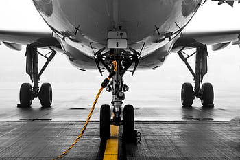 Close-up of a modern aircraft on a misty runway at Zürich Airport, highlighting the landing gear and foggy ambiance. HD wallpaper