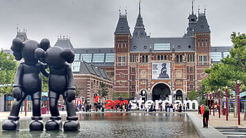 The Rijksmuseum facade with modern art sculptures and reflection in Amsterdam. HD wallpaper