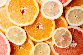Close-up of fresh, sliced citrus fruits showcasing oranges, lemons, and grapefruits. HD wallpaper