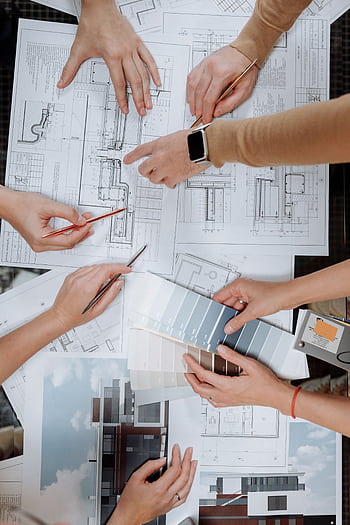 Team working together on architectural blueprints and color swatches. HD phone wallpaper