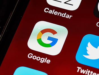 Macro view of a smart displaying Google and other app icons on the home screen. HD wallpaper