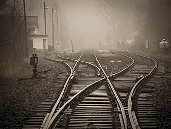 Moody foggy railway tracks in a misty landscape, evoking travel and mystery. HD wallpaper