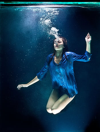 A woman in blue shirt poses elegantly underwater with bubbles. HD phone wallpaper