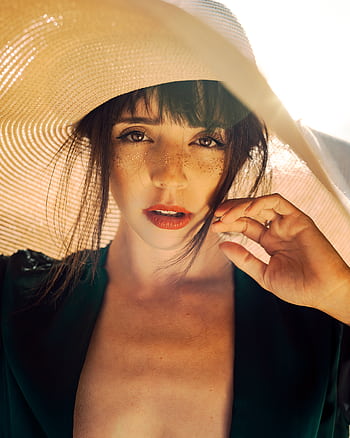 Close-up portrait of a woman with freckles wearing a sun hat, capturing summer vibes. HD phone wallpaper