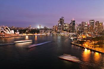 Captivating view of Sydney's illuminated skyline with the iconic Opera House and harbor at night. HD wallpaper
