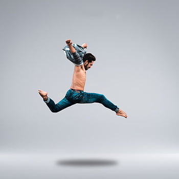 A male dancer shows his agility with a powerful leap captured in a studio setting. HD phone wallpaper