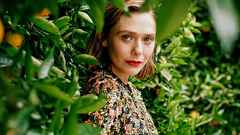 Elizabeth Olsen Girl Model Is Standing In Green Leaves Fruits Tree Branches Background Wearing Black Dress Girls HD wallpaper