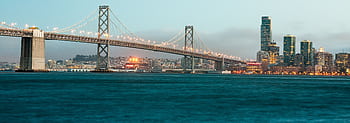 A stunning view of the illuminated Bay Bridge and San Francisco cityscape at twilight. HD wallpaper
