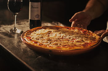 Delicious pepperoni pizza paired with red wine, showcasing a rustic dining experience in Centro, RJ. HD wallpaper