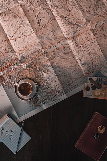 Flat lay of map, coffee, coins, and notebook for travel planning. HD phone wallpaper