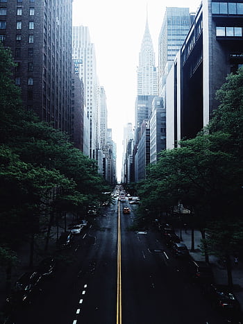 Stunning view of a New York City street lined with skyscrapers, featuring the city's iconic skyline. HD phone wallpaper