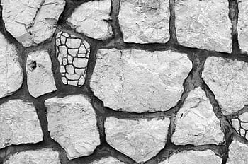 Close-up of a black and white textured stone wall with irregular shapes and patterns. HD wallpaper