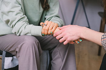 Close-up of two people holding hands during a comforting therapy session. HD wallpaper