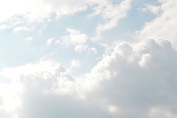 A serene view of thick, fluffy clouds set against a bright blue sky, perfect for backgrounds. HD wallpaper