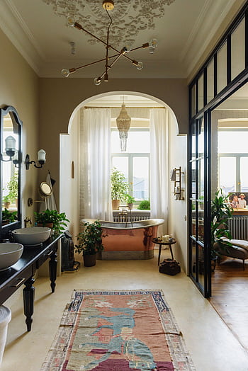 A serene bathroom showcasing vintage and modern design with a copper bathtub and lush plants. HD phone wallpaper