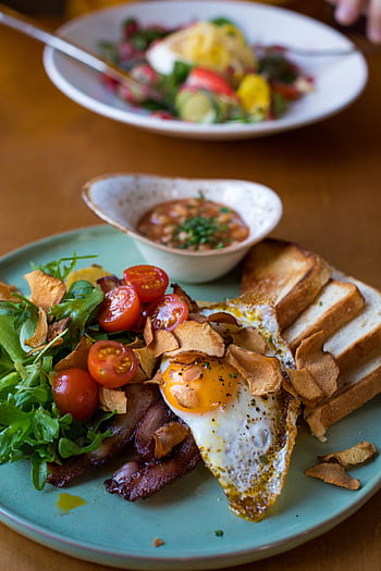 A vibrant breakfast plate featuring bacon, sunny side up egg, and fresh veggies. HD phone wallpaper