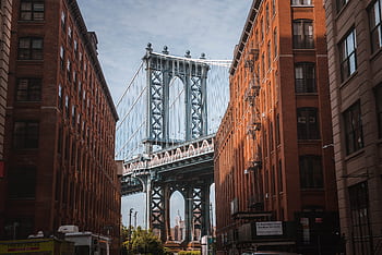 Stunning view of the Manhattan Bridge framed by red-brick buildings in New York City's DUMBO neighborhood. HD wallpaper