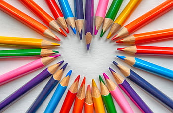 Vibrant colored pencils creatively arranged in a heart shape on a white background. HD wallpaper