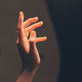 Elegant human hand reaching into soft, warm light creating a serene and artistic effect. HD phone wallpaper