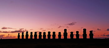 Panoramic view of Easter Island Moai statues silhouetted against a vibrant twilight sky. HD wallpaper