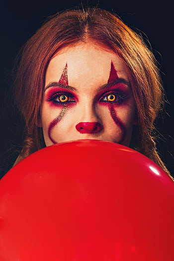 Portrait of a woman with clown makeup holding a red balloon. Halloween vibe. HD phone wallpaper