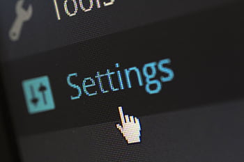A close-up of a computer screen showing the settings button with a cursor hovering over it. HD wallpaper