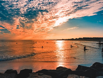 Stunning sunset over Cape May beach with vibrant colors and seashore silhouettes. HD wallpaper