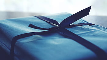 A close-up of a beautifully wrapped blue gift box with a ribbon, perfect for special occasions. HD wallpaper