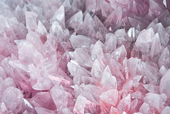 A detailed close-up of rose quartz crystals showcasing their pink hues and translucent nature. HD wallpaper
