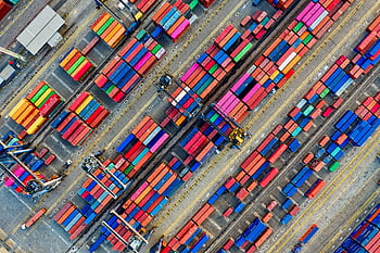 Aerial view of vibrant shipping containers at a busy Jakarta port, showcasing global trade. HD wallpaper