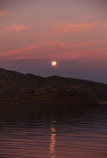A calm landscape with moon reflecting on peaceful waters against a dusk sky. HD phone wallpaper