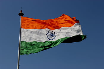 The Indian national flag waves proudly against a clear blue sky, symbolizing unity and pride. HD wallpaper