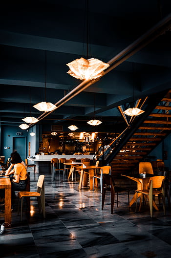 Elegant modern café with warm lighting and contemporary decor, creating a cozy atmosphere. HD phone wallpaper