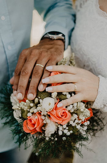 Hands of the bride and groom with wedding rings and floral bouquet, symbolizing love and commitment. HD phone wallpaper