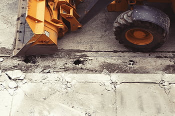Close-up of an excavator working on road construction, showcasing the industrial process. HD wallpaper