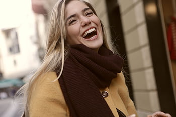 Vibrant portrait of a joyful woman laughing outdoors in winter clothing. Radiates happiness. HD wallpaper