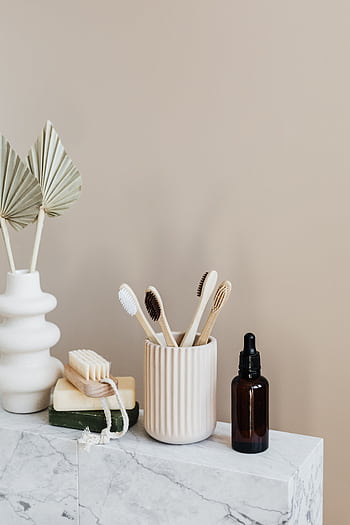 Stylish arrangement of eco-friendly bathroom products on marble with beige backdrop. HD phone wallpaper