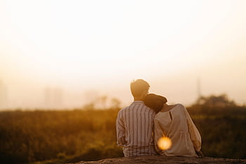 A couple enjoys a serene moment together during a sunset in Gia Lai, Vietnam. HD wallpaper