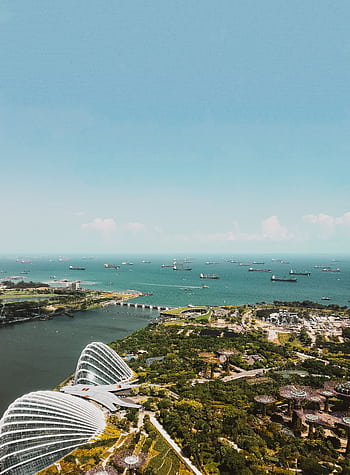 Breathtaking aerial view of Singapore's skyline with ocean and greenery, showcasing architecture and nature. HD phone wallpaper