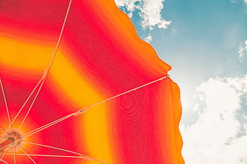 Colorful beach umbrella with vivid stripes under a bright summer sky in Croatia. HD wallpaper