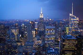 A stunning nighttime view of New York City skyline with illuminated skyscrapers. HD wallpaper