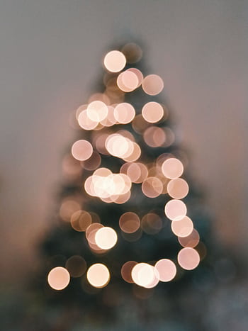 Soft focus of a Christmas tree showcasing warm bokeh light circles, creating a festive and cozy atmosphere. HD phone wallpaper